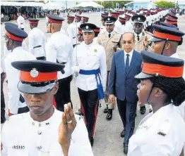  ??  ?? National Security Minister Dr Horace Chang (centre) conducts a review of 147 new police recruits graduating from the National Police College of Jamaica’s Harman Barracks Campus.