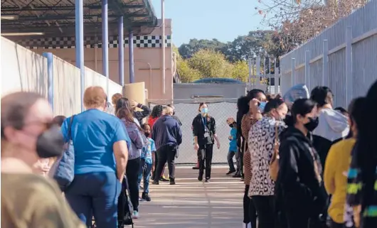  ?? ALLISON ZAUCHA/THE NEW YORK TIMES ?? People line up for COVID-19 tests Jan. 6 at a school in Gardena, Calif. More than 250,000 public school students have left the state’s rolls since 2019.