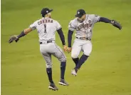  ?? Kevork Djansezian / Getty Images ?? Carlos Correa (left) and George Springer celebrate after the last out of the Astros’ 11-inning win.