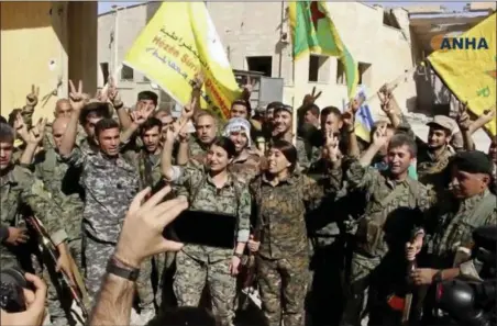  ?? HAWAR NEWS AGENCY VIA AP ?? This frame grab from video released Tuesday and provided by Hawar News Agency, a Syrian Kurdish activist-run media group, shows fighters from the U.S.-backed Syrian Democratic Forces (SDF) celebratin­g their victory in Raqqa, Syria. U.S.-backed Syrian...