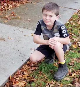  ??  ?? Nine-year-old Thomas Brock shows the new patch of concrete footptah replaced after a leaking gas main was fixed when he nagged his mother he could smell gas.