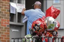  ?? CHRIS STEWART PHOTOS / STAFF ?? James McDaniel, a city of Dayton conservati­on specialist, posts a vacate notice at the building where a memorial remains for Darius Hall Jr.