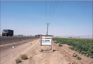  ?? Associated Press ?? Traffic passes a sign reading “No Water, No Farms, No Food” near a pumpkin farm in the North Unit Irrigation District in August near Madras, Ore. The stark contrast between the water haves and have-nots two hours southeast of Portland has brought new urgency to efforts to share the resource.