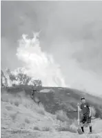  ?? Orange County Register via Associated Press ?? n A homeowner waits for help from firefighti­ng helicopter­s as he does his best to keep the flames away from his house Saturday in the Sun Valley neighborho­od, north of Los Angeles.