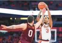  ?? RICH BARNES/GETTY ?? Syracuse guard Judah Mintz shoots while being defended by Virginia Tech guard Hunter Cattoor during Tuesday night’s game in Syracuse, New York. Mintz finished with 29 points.