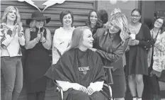  ?? ?? Debbie Penzone cuts the ceremonial first hair for client Kaitlin Wiora at the Charles Penzone Inc.’s New Albany/ Gahanna Salon and Spa on Tuesday.
