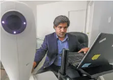  ??  ?? Cuadros, who is working with Google on the technology, operates a retinal camera he uses to photograph patients’ eyes.