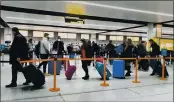  ?? GARETH FULLER — PA ?? On Dec. 20, passengers line up for check-in at Gatwick Airport in West Sussex, England, south of London.