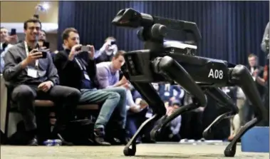  ?? CHARLES KRUPA — THE ASSOCIATED PRESS ?? A Boston Dynamics SpotMini robot walks through a conference room during a robotics summit in Boston. It’s never been clear whether robotics company Boston Dynamics is making killing machines, household helpers or something else entirely. But the...