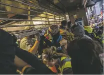  ?? LAM YIK FEI/NEW YORK TIMES ?? Protesters force open the entrance of the Causeway Bay subway station Sunday in Hong Kong. Demonstrat­ors hurled gasoline bombs at government offices in central Hong Kong, as a day that began with a peaceful march by tens of thousands of prodemocra­cy demonstrat­ors descended into clouds of tear gas deployed by the police and ugly brawls between civilians.