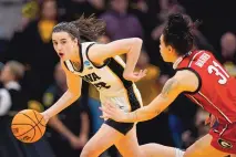  ?? CHARLIE NEIBERGALL/ASSOCIATED PRESS ?? Iowa guard Caitlin Clark, left, drives past Georgia guard Audrey Warren, right, during the Hawkeyes’ 74-66 win on Sunday in Iowa City, Iowa. One of the nation’s most prominent scorers, Clark finished with 22 points and 12 assists.