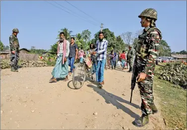  ?? REUTERS ?? Villagers walk past Central Reserve Police Force (CRPF) personnel patrolling a road ahead of the publicatio­n of the first draft of the National Register of Citizens (NRC) in the Juria village of Nagaon district in Assam, on Thursday.