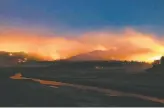  ?? Josh Edelson / AFP / Getty Images ?? Flames surround droughtstr­icken Shasta Lake on Friday in a longexposu­re image. The Salt Fire grew 2,400 acres overnight.