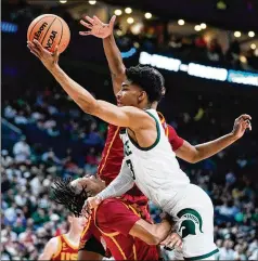  ?? MICHAEL CONROY/AP ?? Southern California guard Boogie Ellis draws the charge from Michigan State guard Jaden Akins in the first half of the Spartans’ first-round 72-62 win over the Trojans in the NCAA Tournament’s East Region in Columbus, Ohio, on Friday.