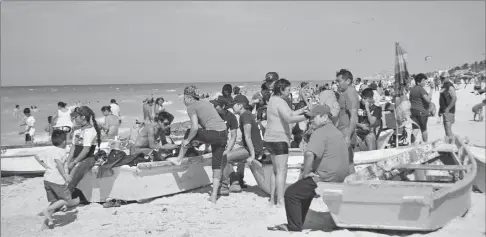  ??  ?? Paseantes yucatecos que aprovechar­on los 26 grados del último domingo de marzo para visitar las playas de Progreso, donde incluso se instalaron en los alijos y las lanchas