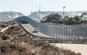  ??  ?? A BORDER PATROL vehicle drives on the San Diego-Tijuana internatio­nal border wall.