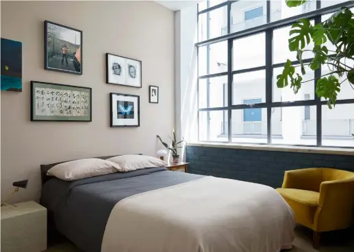  ??  ?? BEDROOM
Perfectly proportion­ed, the mid-century bedside table is from Archive Furniture and a gallery wall includes a print by Damien Hirst, a Jack Latham photograph and an antique Japanese manuscript. The tub chair brings a dash of colour