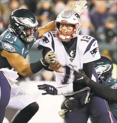  ?? Tim Hawk / TNS ?? Patriots quarterbac­k Tom Brady is hit by Eagles defenders during Sunday’s game in Philadelph­ia.