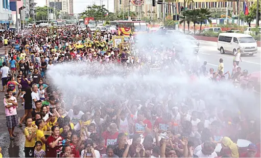  ?? (Ali Vicoy) ?? SWOOSH – Catholic devotees are doused with water in Baclaran, Parañaque City, yesterday during the Feast of St. Rita de Cascia, Patron Saint of the Impossible, Abused Wives, and Widows.