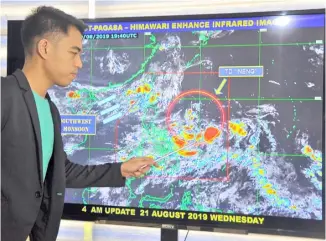  ?? ANALY LABOR ?? WEATHER forecaster Benison Estareja points to the eye of tropical depression “Ineng” estimated at 930 km East of Virac, Catanduane­s held at PAGASA office in Quezon City.