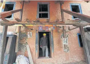  ?? AFP ?? A worker walks out of an earthquake­damaged house secured for retrofitti­ng in the village of Dungkharka in Kavre district, some 45km east of Kathmandu three years ago.