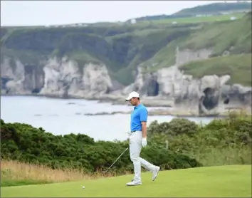  ?? Andy Buchanan/ Getty Images ?? MAN VS. NATURE Rory McIlroy walks through a practice round on Royal Portrush, a 131year- old course set on the northern coast of Northern Ireland.