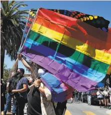  ?? Carlos Avila Gonzalez / The Chronicle 2020 ?? Jose Hernandez sells flags during a march to show support for the movement for racial equality from the LGBTQ community in June in S. F.