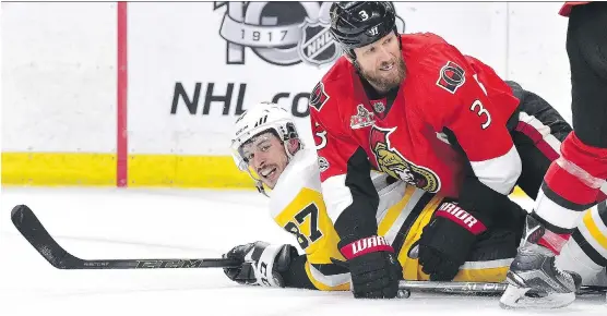  ?? MINAS PANAGIOTAK­IS/GETTY IMAGES ?? Pittsburgh’s Sidney Crosby is smothered by Ottawa’s Marc Methot in Game 6 of the East final, Tuesday. The hometown Sens scored a 2-1 win to force Game 7.