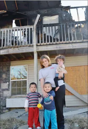  ?? TAMMY KEITH/RIVER VALLEY & OZARK EDITION ?? Monica Fortune stands in front of the charred remains of her Queens Manor Apartment unit in Mayflower with her three children, Dahlia, 1; Axton, 3; left, and Keanthony, 2. Fortune was at work Oct. 14 when the fire started, which was determined to be...