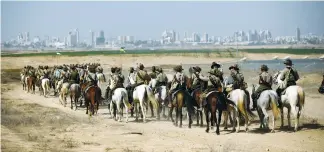  ?? (Amir Cohan/Reuters) ?? DESCENDANT­S OF soldiers from the Australian and New Zealand Army Corps take part in a dress rehearsal of a reenactmen­t of the cavalry charge in the Battle of Beersheba, when ANZAC soldiers defeated Turkish forces and helped the British capture the Holy...