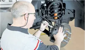  ?? HANDOUT/GENERAL MOTORS ?? A technician checks the front brake system during a vehicle inspection.