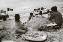  ??  ?? The Puac family, from the Beaumont area, builds a sand structure during their visit to Crystal Beach on Sunday. The state reopened beaches on May 1 as part of its reopening plan.