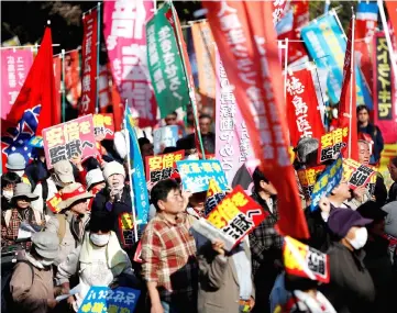  ?? — Reuters photo ?? Protesters hold placards reading ‘Stop constituti­on revision and war’ and ‘Abe should go prison’ as they shout slogans during a march denouncing Abe over a suspected cover-up of a cronyism scandal and his administra­tion in Tokyo.