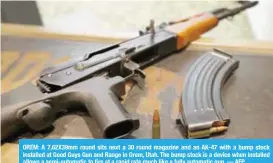  ?? — AFP ?? OREM: A 7,62X39mm round sits next a 30 round magazine and an AK-47 with a bump stock installed at Good Guys Gun and Range in Orem, Utah. The bump stock is a device when installed allows a semi-automatic to fire at a rapid rate much like a fully...