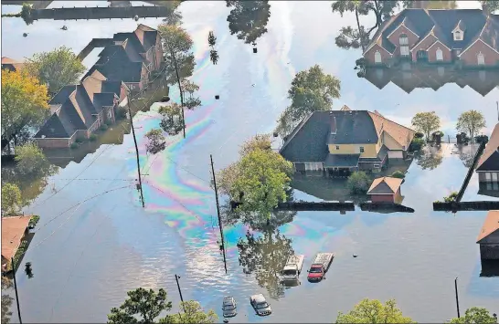  ?? [GERALD HERBERT/THE ASSOCIATED PRESS] ?? Petroleum spill-off flows atop floodwater­s in Beaumont, Texas, Thursday. Health officials are urging people not to even touch the water, and to wash if they can’t avoid it.