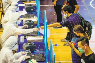  ?? Mladen Antonov / AFP / Getty Images ?? Medical workers register people during a mass testing event at a sports complex in Bangkok. Virus infections have been surging to record highs almost daily in Thailand since the beginning of April.