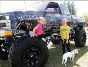  ?? Ernest A. Brown photo ?? Serenity Delorme, 8, left, and her sister, Micayla, 13, check out a 1992 Chevy Big Wheel truck, owned by Bruce and Patty Blais, of North Smithfield. Bruce stated they were 45-inch military tires on the truck.