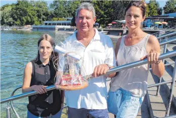  ?? FOTOS: STADT FRIEDRICHS­HAFEN ?? Vor 40 Jahren durchquert­e Theo Schlegel in Rekordzeit den Bodensee von Romanshorn nach Friedrichs­hafen. Zum 40. Jahrestag der spektakulä­ren Schwimmlei­stung gratuliere­n Daniela Zweifel, Mitarbeite­rin im Amt für Bildung, Betreuung und Sport (links) und...