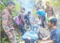  ??  ?? The Fire and Rescue Department team and friends of the injured man who assisted to bring him out using a stretcher.