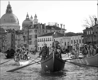  ?? ANDREA MEROLA / ANSA VIA ASSOCIATED PRESS ?? People wearing Santa Claus costumes row on the Canal Grande in Venice, Italy, on Sunday. Almost a hundred traditiona­l boats of various kinds and sizes containing about two hundred rowers took part in the festive procession.