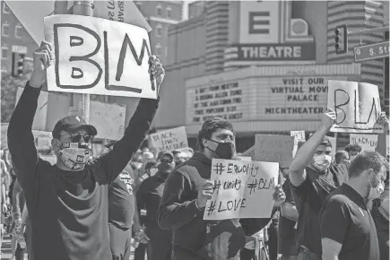  ?? GRANT PERRY ?? At a protest in Ann Arbor, Grant Perry (left), Mike McCray, Grant Newsome and Jay Harbaugh (far right) were among former and current players and coaches from the Michigan Wolverines football program who participat­ed.