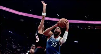  ?? (AP PHOTO/STEVE DYKES) ?? Minnesota Timberwolv­es center Karl-Anthony Towns, right, drives to the basket as Portland Trail Blazers forward Toumani Camara, left, defends during the first half of Thursday’s game.