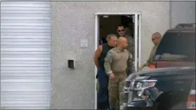  ?? WPLG-TV VIA AP ?? This frame grab from video provided by WPLG-TV shows FBI agents escorting Cesar Sayoc, in sleeveless shirt, in Miramar, Fla., on Friday. Sayoc is an amateur body builder and former male stripper, a loner with a long arrest record who showed little interest in politics until Donald Trump came along. On Friday, he was identified by authoritie­s as the Florida man who put pipe bombs in small manila envelopes, affixed six stamps and sent them to some of Donald Trump’s most prominent critics.