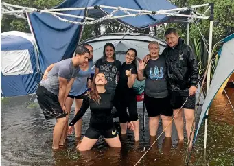  ??  ?? The extended Cooper family, still smiling, at their flooded campsite at Matai Bay, Northland, on Christmas morning.