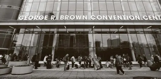  ?? Photos by Karen Warren / Staff photograph­er ?? A line of over 200 people forms at the George R. Brown Convention Center. The shelter hit capacity at about 500 people within hours of opening, an official said.