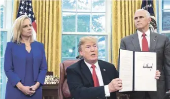  ?? EFE ?? Decreto. El presidente estadounid­ense, Donald Trump, rodeado por la secretaria de Seguridad Nacional, Kirstjen Nielsen, y el vicepresid­ente Mike Pence, muestra la orden ejecutiva para detener la separación de los niños.
