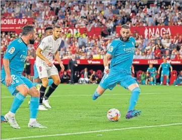  ?? REUTERS ?? Real Madrid forward Karim Benzema scores their third goal against Sevilla on Sunday.