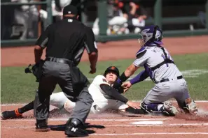  ?? AP Photo/Jed Jacobsohn ?? ■ San Francisco Giants’ Wilmer Flores is tagged out at home by Colorado Rockies’ Tony Wolters during the second inning of a baseball game Thursday in San Francisco.