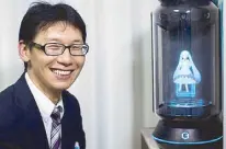  ?? AFP ?? Japanese Akihiko Kondo poses next to a hologram of Japanese virtual reality singer Hatsune Miku at his apartment in Tokyo a week after marrying her.