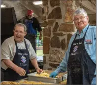 ??  ?? Ken Scott and Larry Lisko prepare fish for frying.